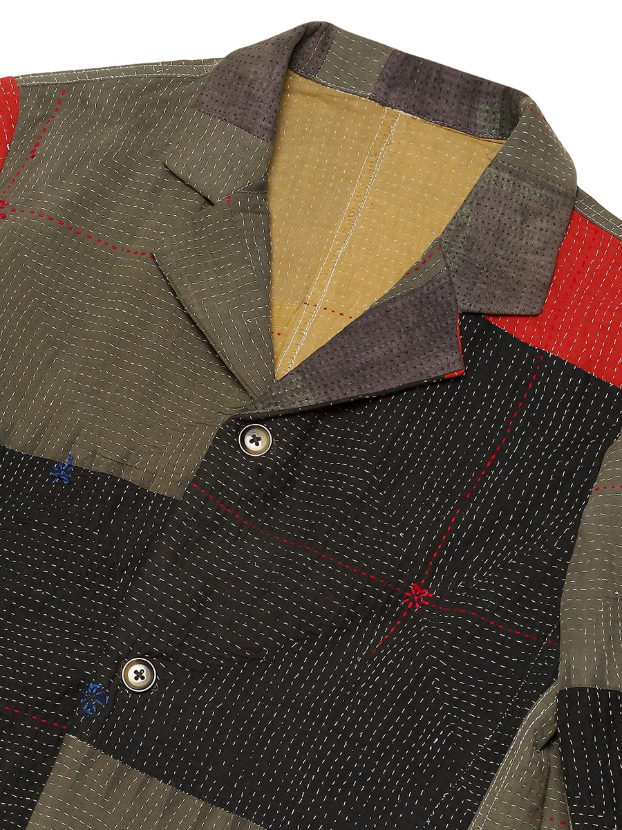 Close-up of a patchwork jacket with various colored fabric pieces.