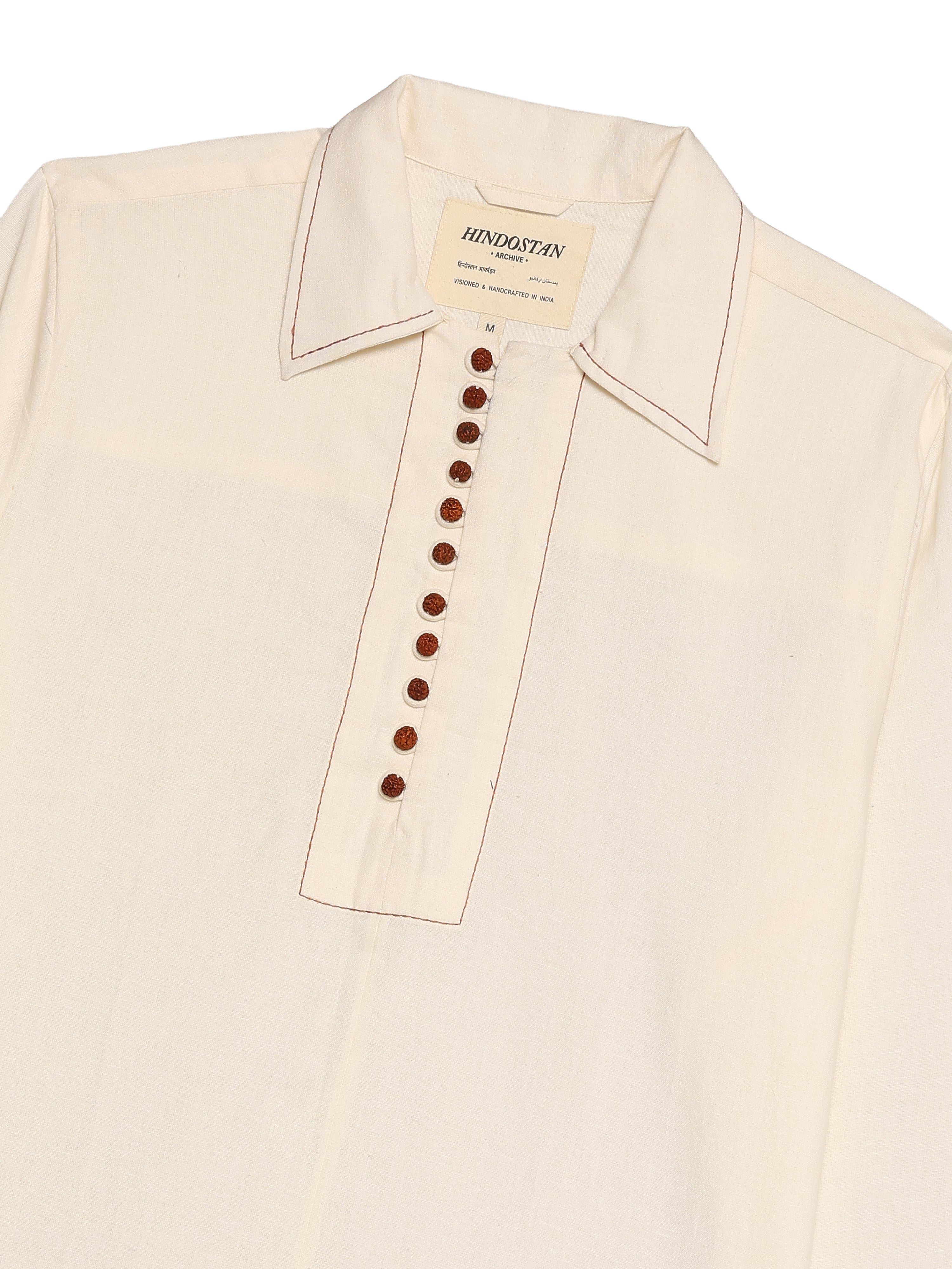 Beige shirt with brown buttons on a white background, featuring Hindostan label.
