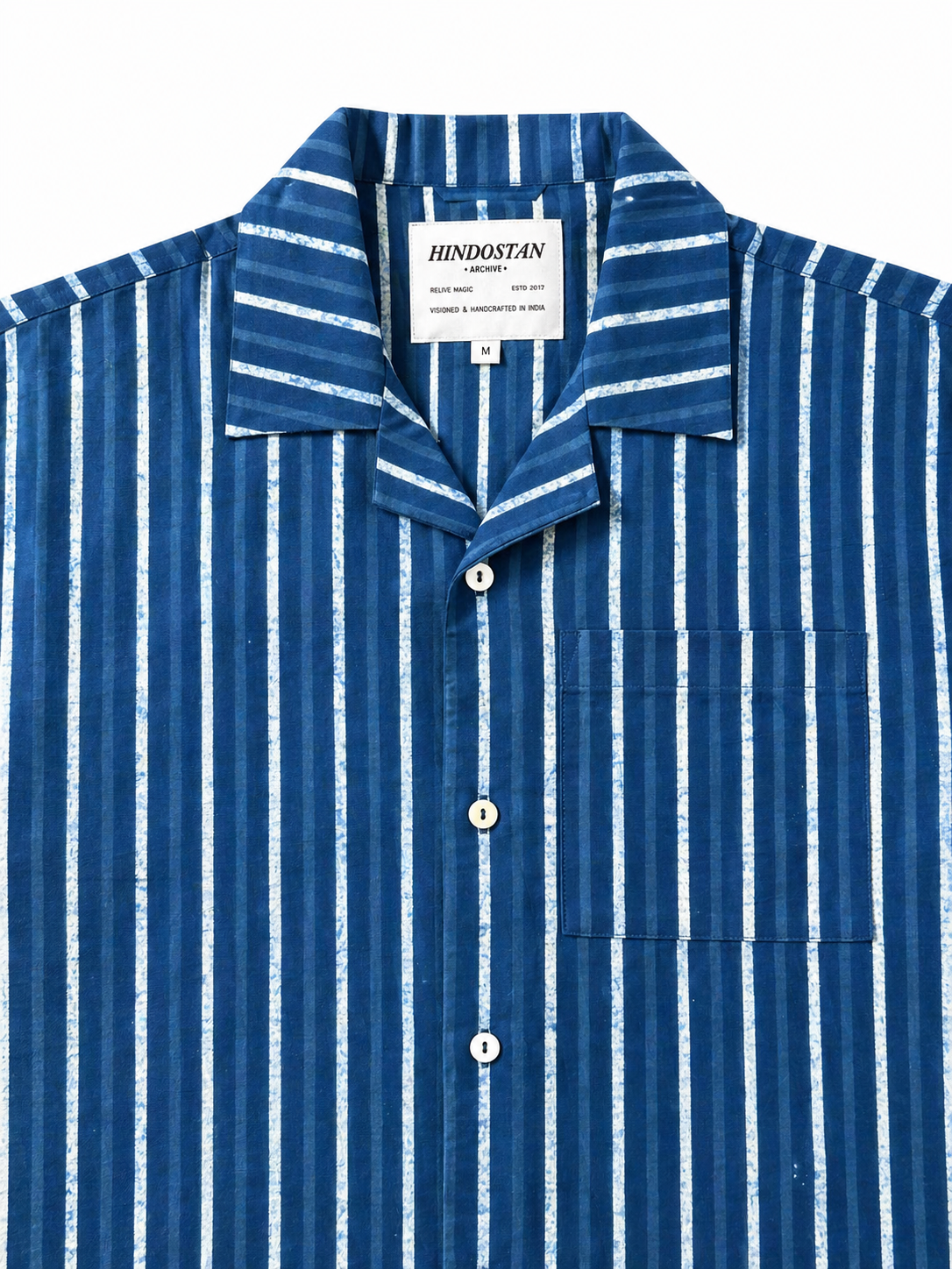 Blue and white striped shirt with a visible brand label on a white background