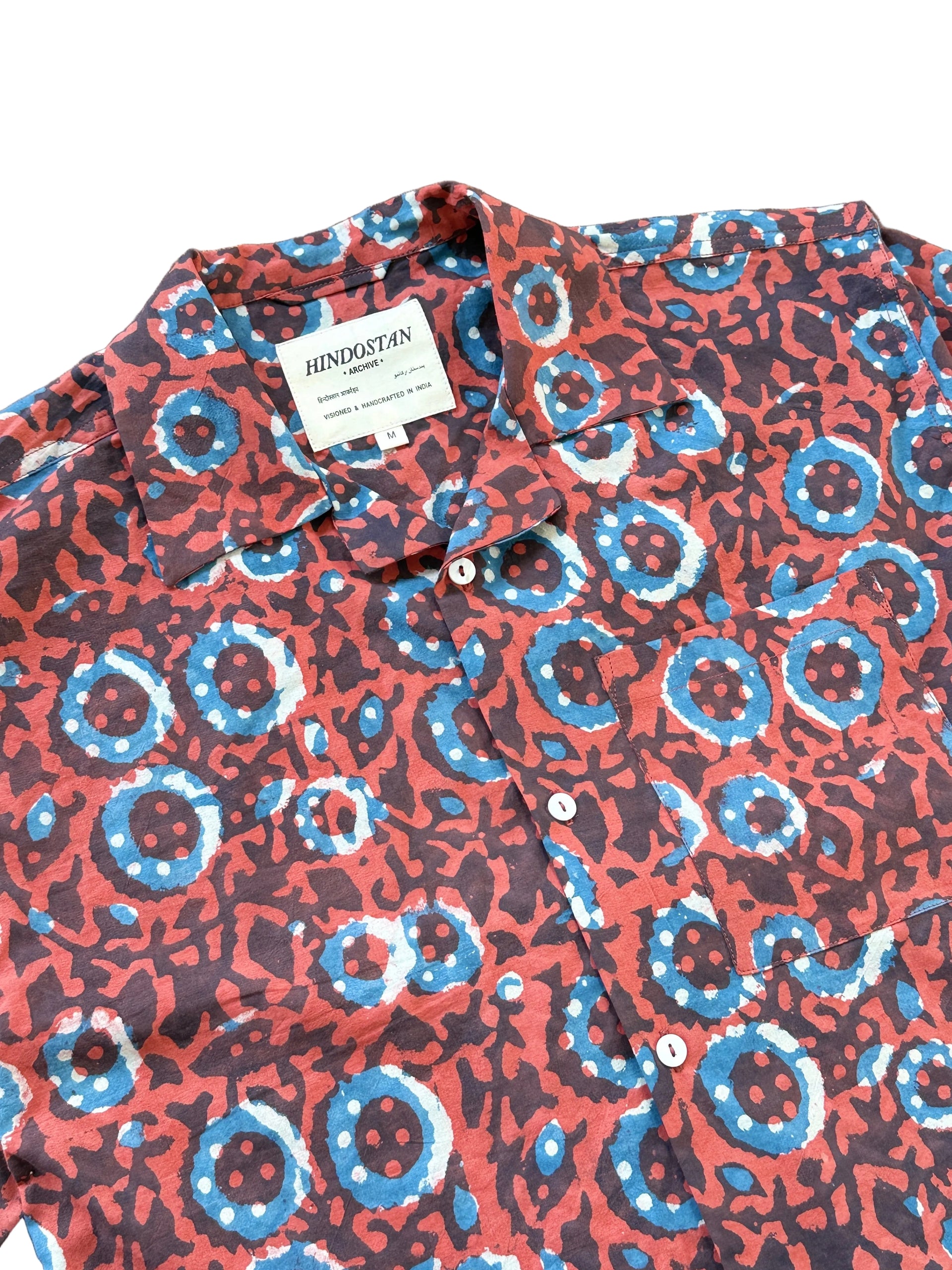 Patterned shirt with a visible brand label on a wooden surface