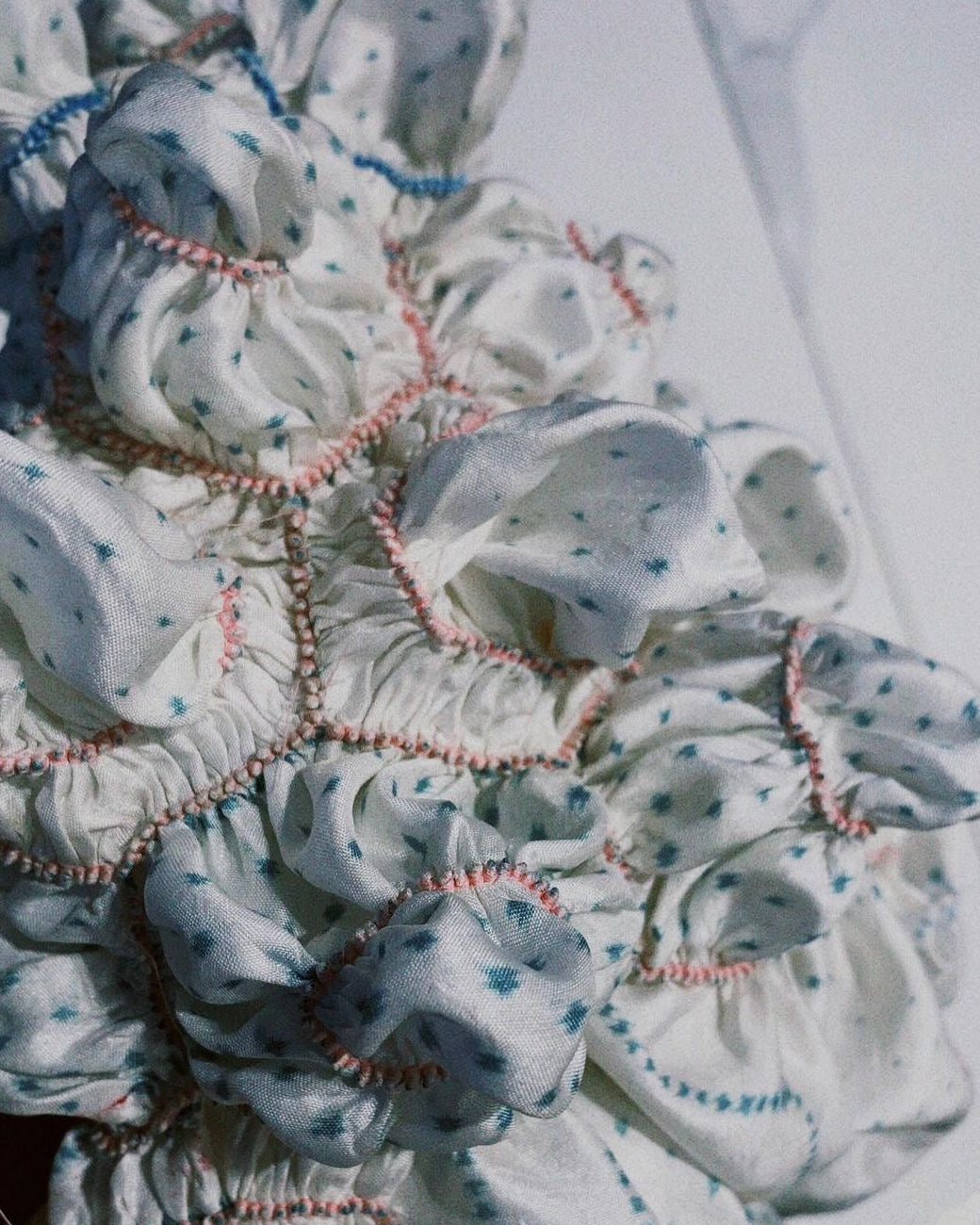 Close-up of a textured fabric with floral patterns and embroidered details.