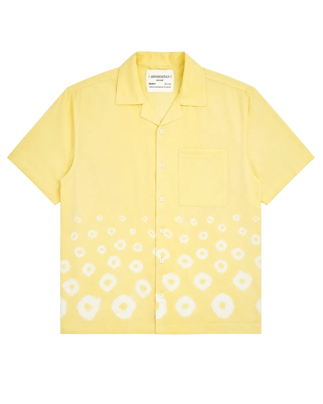 Front view of a yellow short-sleeve shirt with white bandhani print hem on a white background – Hindostan Archive